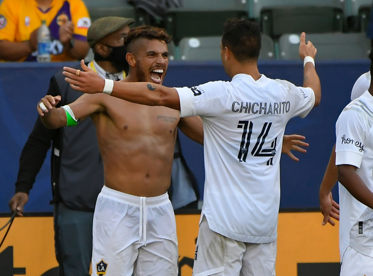 Jonathan dos Santos is shirtless as Galaxy teammate Javier “Chicharito” Hernández congratulates him on his goal May 8, 2021.