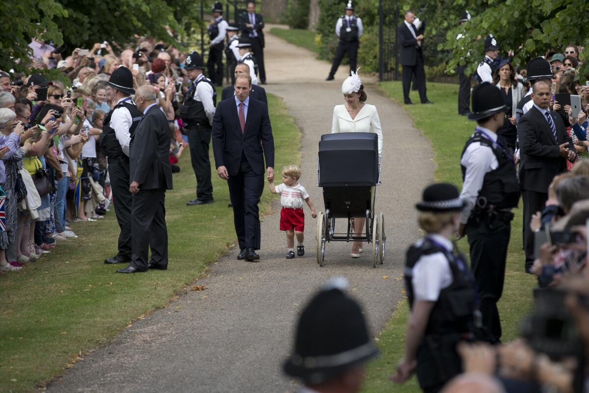 Britain's Prince William, Kate the Duchess of Cambridge and their son, Prince George, bring the carriage with Princess Charlotte to her christening Sunday at St. Mary Magdalene Church in Sandringham, England.