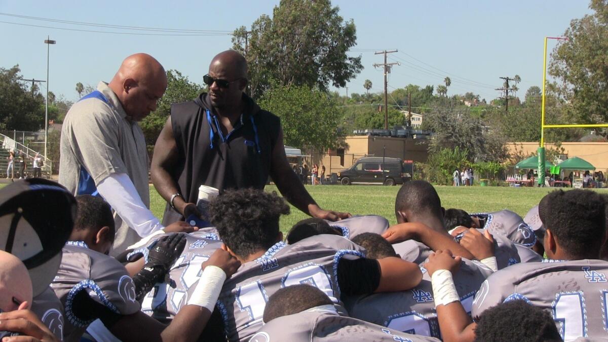 Los Angeles players gather with Coach Eric Scott looking on before defeating Hamilton, 35-7.