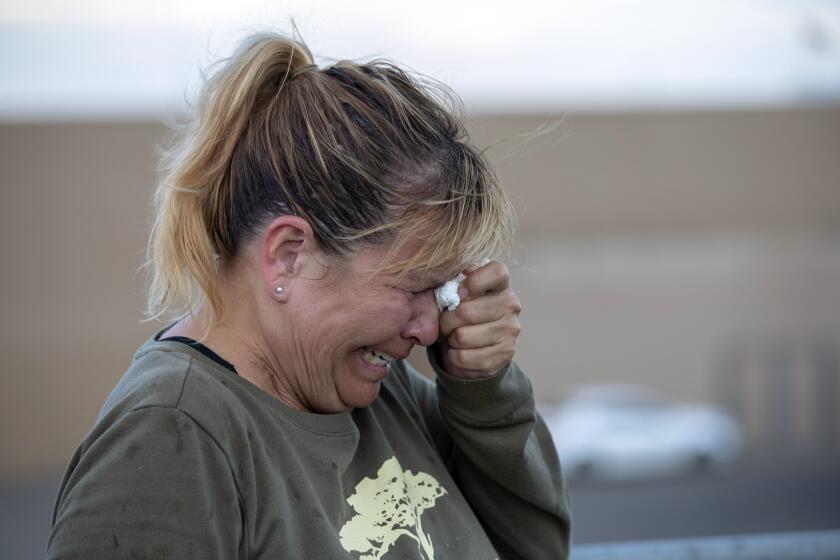 Edie Hallberg cries while speaking to police outside a Walmart store where a shooting occurred earlier in the day as she looks for her missing mother Angie Englisbee, who was in the store during the attack in El Paso, Texas, Saturday, Aug. 3, 2019. Multiple people were killed and one person was in custody after a shooter went on a rampage at a shopping mall, police in the Texas border town of El Paso said. (AP Photo/Andres Leighton)