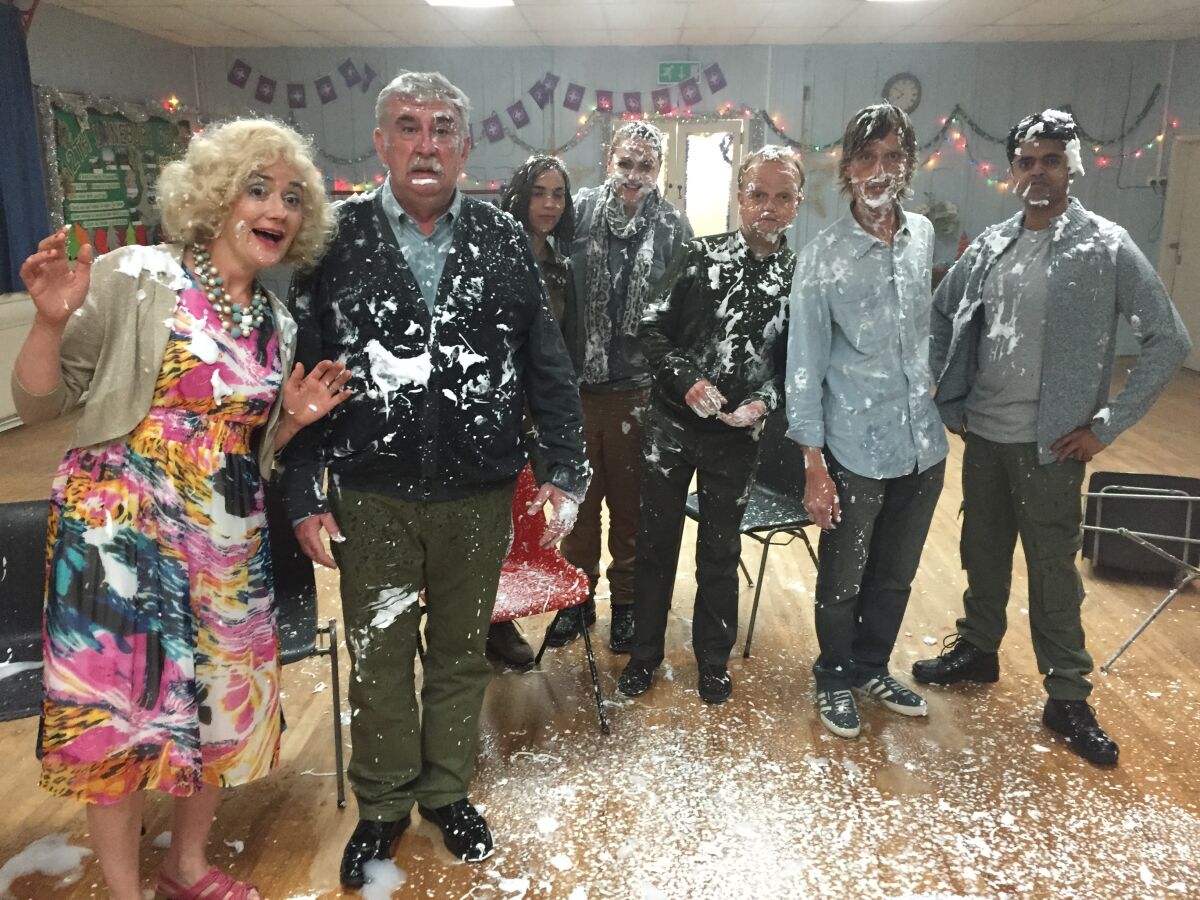 A group of people at a party covered in cake frosting