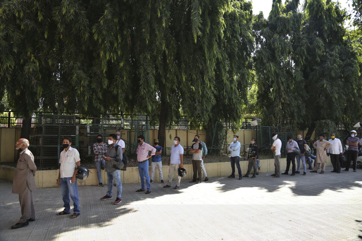 People wait for coronavirus test results in Jammu, India.
