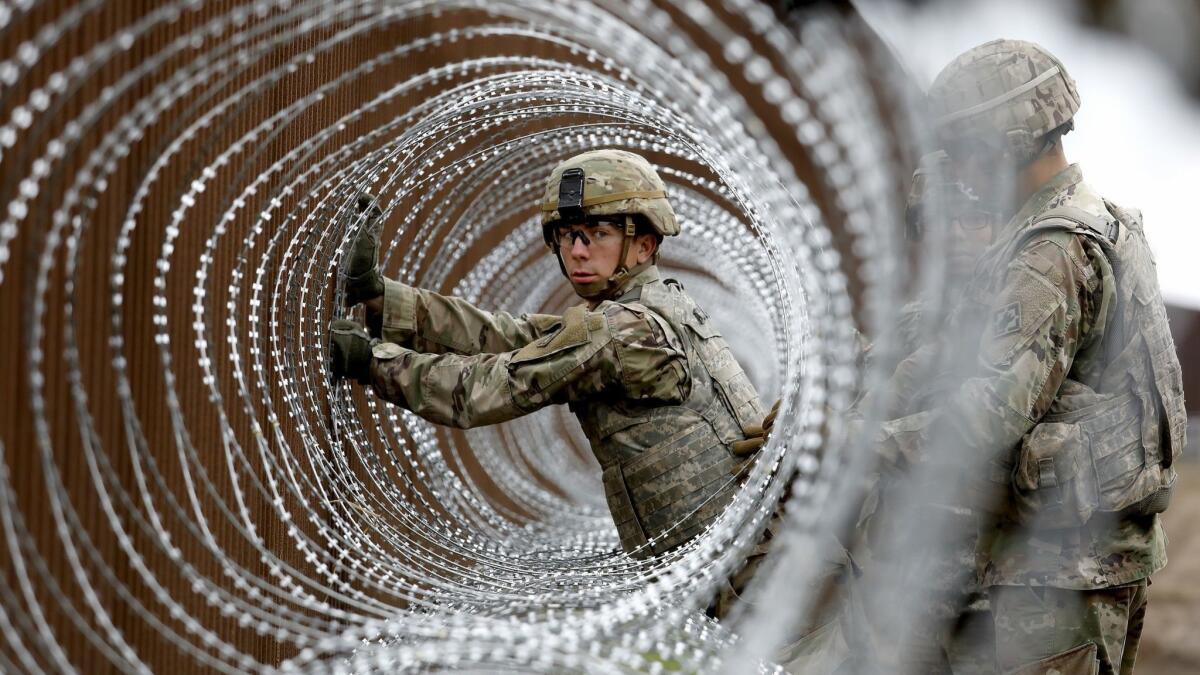 Alexander Gomez of the U.S. Army installs coils of concertina wire near the banks of the Rio Grande along the U.S. border with Mexico in Brownsville, Texas, on Nov. 13, 2018.