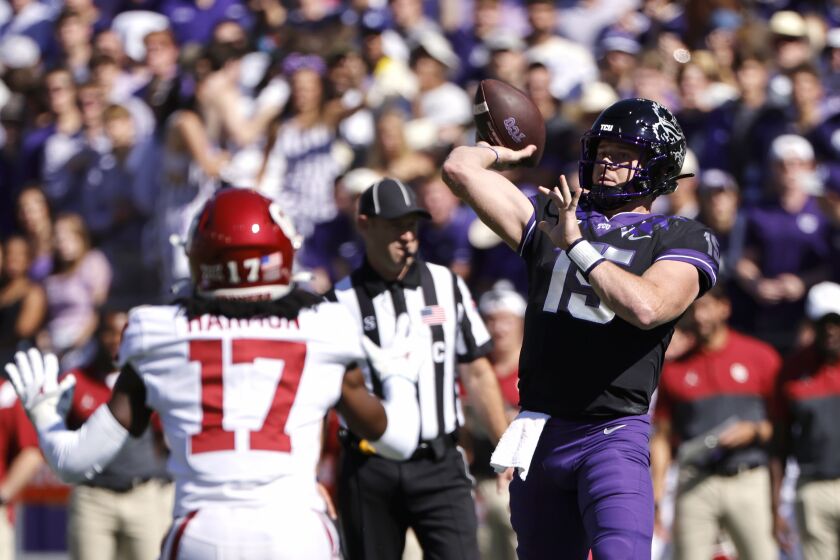 TCU quarterback Max Duggan (15) throws a touchdown pass as Oklahoma defensive back Damond Harmon (17) defends during the first half of an NCAA college football game Saturday, Oct. 1, 2022, in Fort Worth, Texas. (AP Photo/Ron Jenkins)