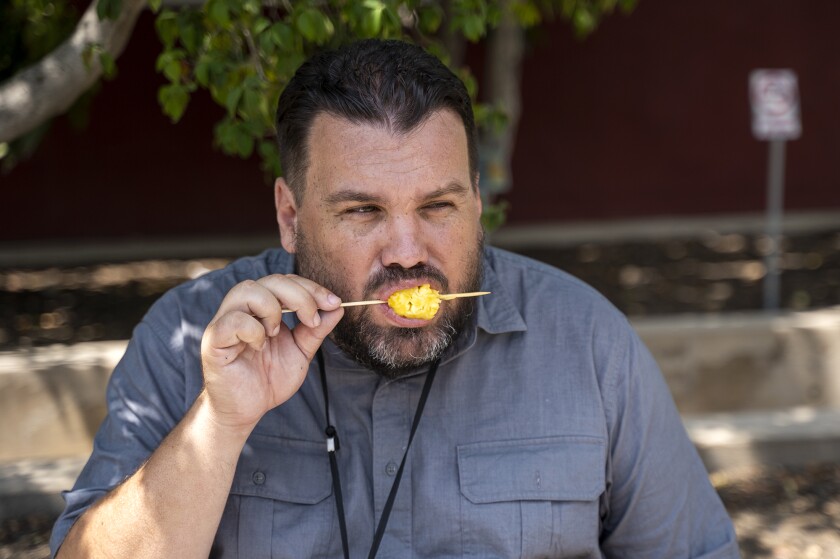 Daily Pilot reporter Matt Szabo tries the grilled pineapple on a stick at the O.C. Fair on Thursday.