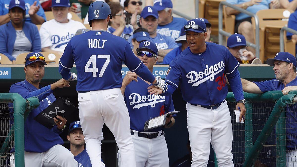 Tyler Holt is congratulated by Dodgers Manager Dave Roberts (30) after scoring in the seventh inning against the Seattle Mariners.