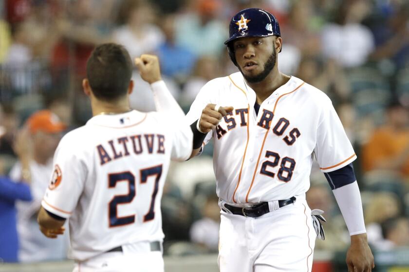 Jon Singleton, right, is met by Jose Altuve, left, after scoring in the fourth inning on a Robbie Grossman bunt. The Astros defeated the Angels, 8-5.