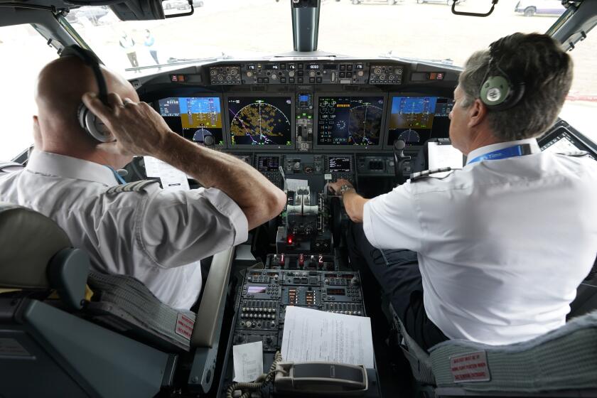 CORRECTS SPELLING OF FIRST NAME TO PETE, NOT PET - American Airlines pilot captain Pete Gamble, left, and first officer John Konstanzer conduct a pre-flight check in the cockpit of a Boeing 737 Max jet before taking off from Dallas Fort Worth airport in Grapevine, Texas, Wednesday, Dec. 2, 2020. American Airlines took its long-grounded Boeing 737 Max jets out of storage, updating key flight-control software, and flying the planes in preparation for the first flights with paying passengers later this month. (AP Photo/LM Otero)