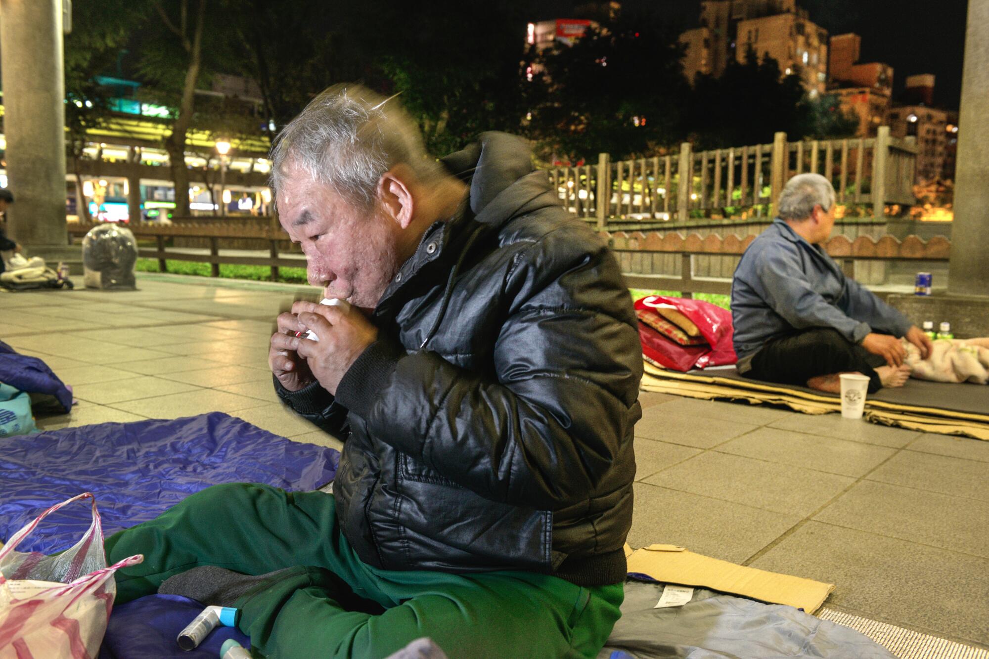 Hsu Chong-chi, 64, uses an inhaler for his asthma before bedtime at Taipei's Bangka Park.