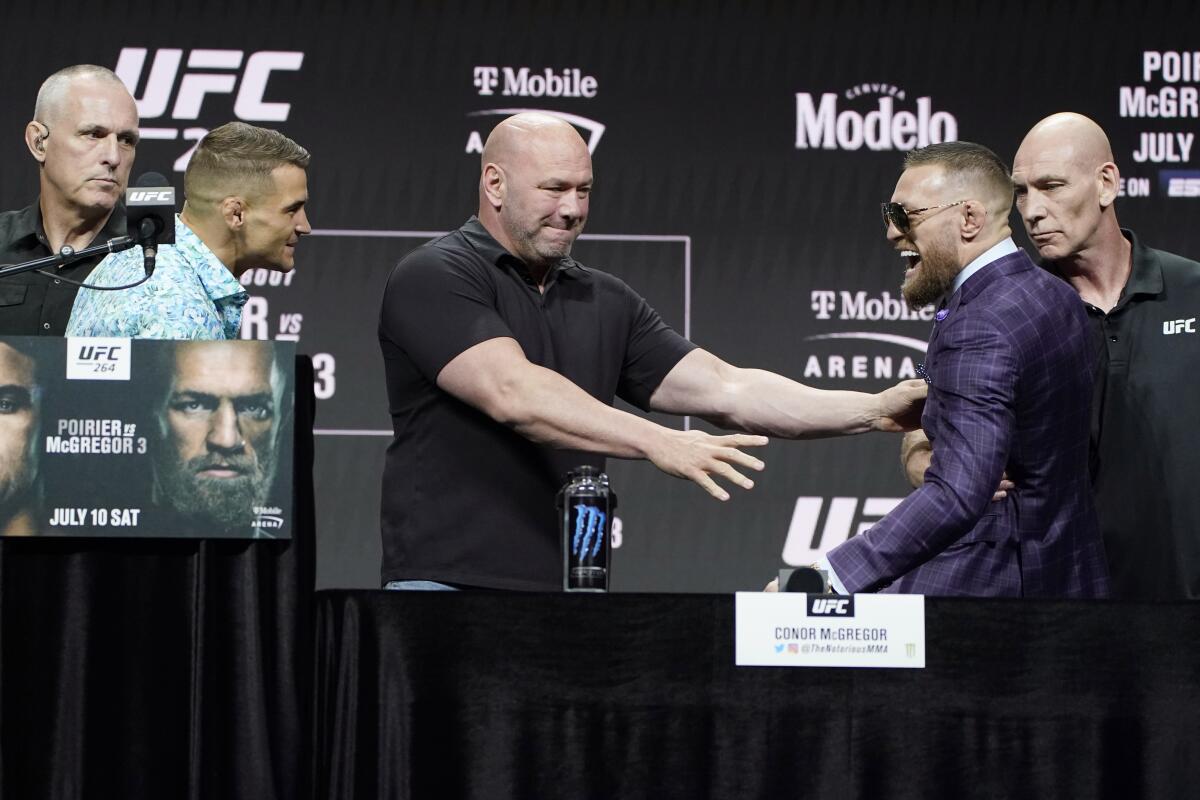 Dana White, center, UFC President, holds Conor McGregor away from Dustin Poirier 