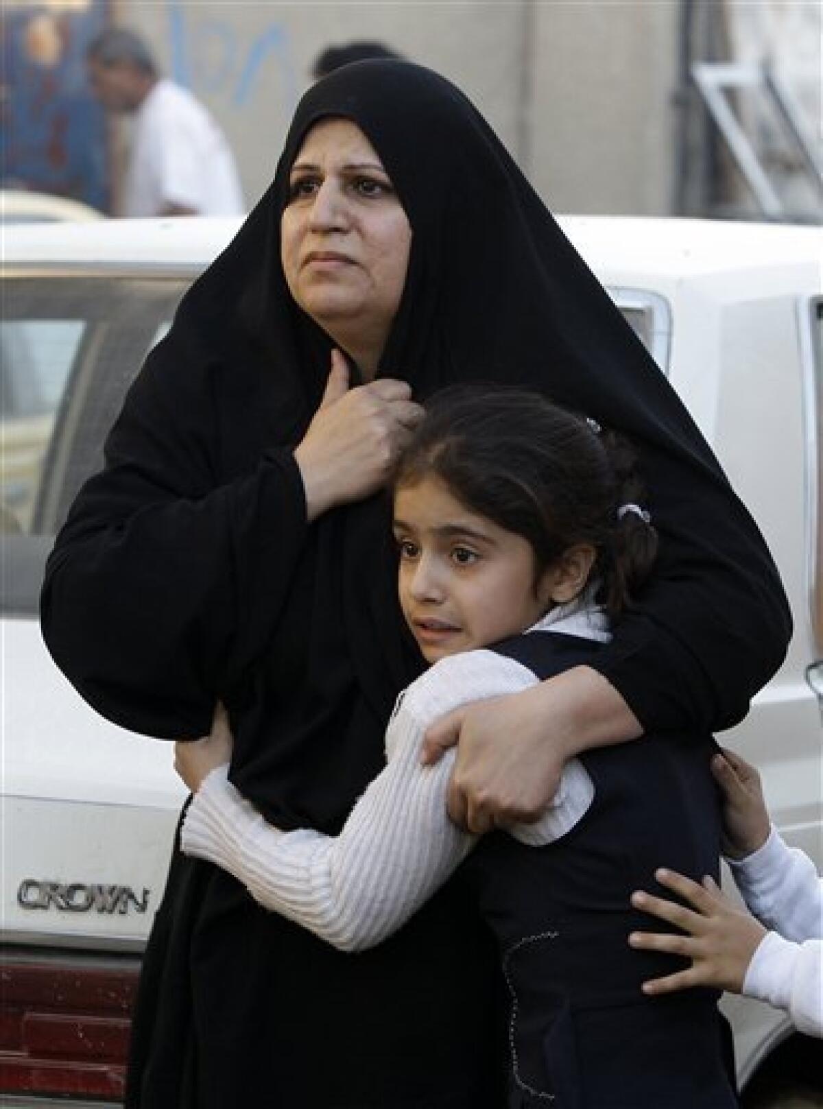 An Iraqi women hugs her daughter at the site of a car bomb attack in Baghdad, Iraq, Tuesday, Dec. 15, 2009. A series of car bombs ripped through downtown Baghdad near the heavily fortified Green Zone. (AP Photo/Hadi Mizban)