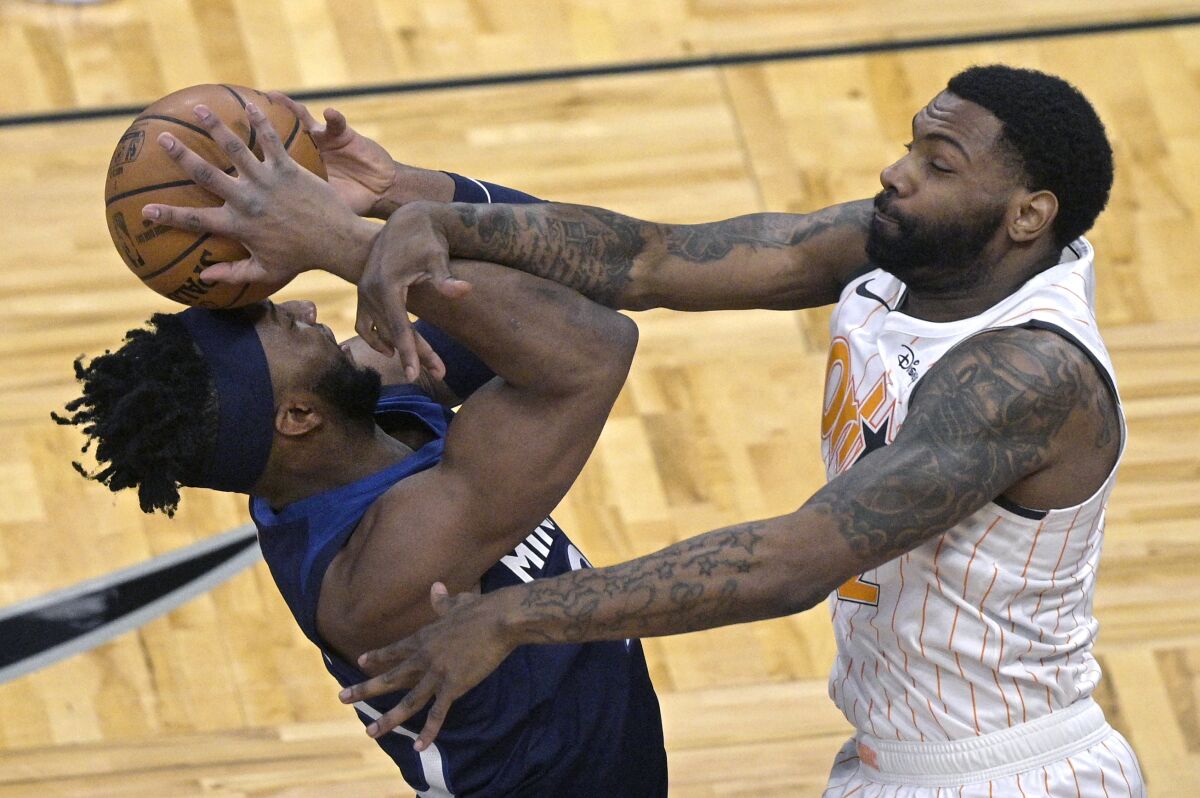 Minnesota Timberwolves forward Josh Okogie, left, is fouled by Orlando Magic guard Sindarius Thornwell while going up to shoot during the first half of an NBA basketball game, Sunday, May 9, 2021, in Orlando, Fla. (AP Photo/Phelan M. Ebenhack)