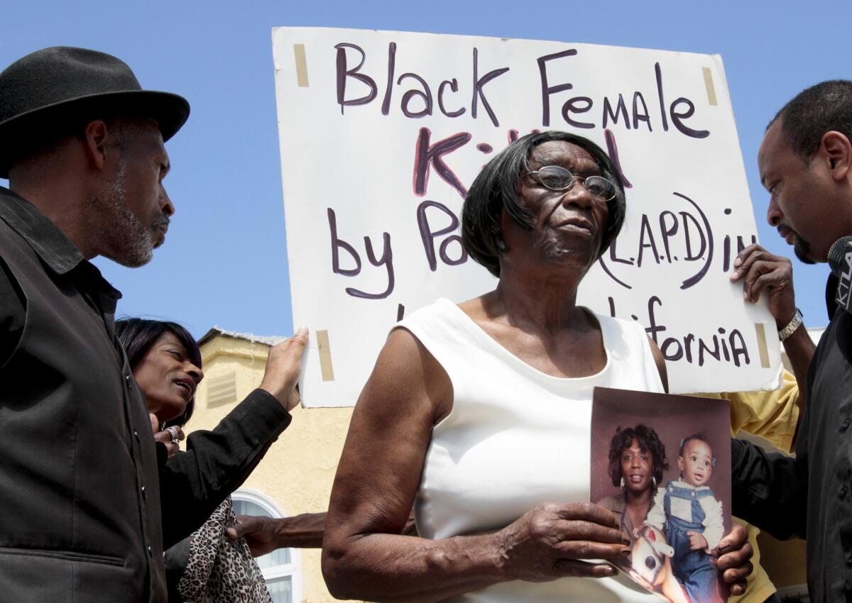 Ada Moses holds a photo of her granddaughter, Alesia Thomas, 35, and great-granddaughter as she speaks during a news conference.