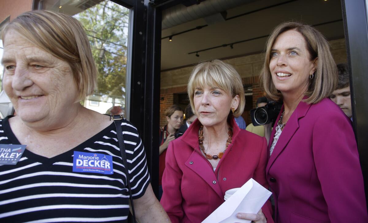 Massachusetts Atty. Gen. and Democratic candidate for governor Martha Coakley, center, and U.S. Rep. Katherine Clark, D-Mass., follow a supporter out of the Kickstand Cafe after a campaign event in Arlington.