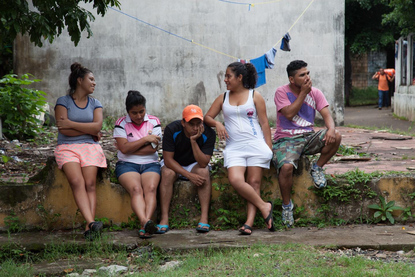 Youth from La Trinidad sit around and talk at the Jose Marti Federation school, currently serving as a shelter for the Fuego Volcano-affected community members. Originally from Huehuetenango, roughly two hundred families fled to MÈxico in 1982 escaping State-repression during the war. In 1998, after the Peace Accords, the families were given land at the foot of the Fuego Volcano as part of an agreement for returning refugees. Today, La Trinidad is one of the most affected communities due to the June 3 eruption. Their community was not destroyed but has been deemed uninhabitable due to imminent lahar flows and the 235 families await an uncertain future once again. Escuintla, Escuintla, Guatemala. September 13, 2018.