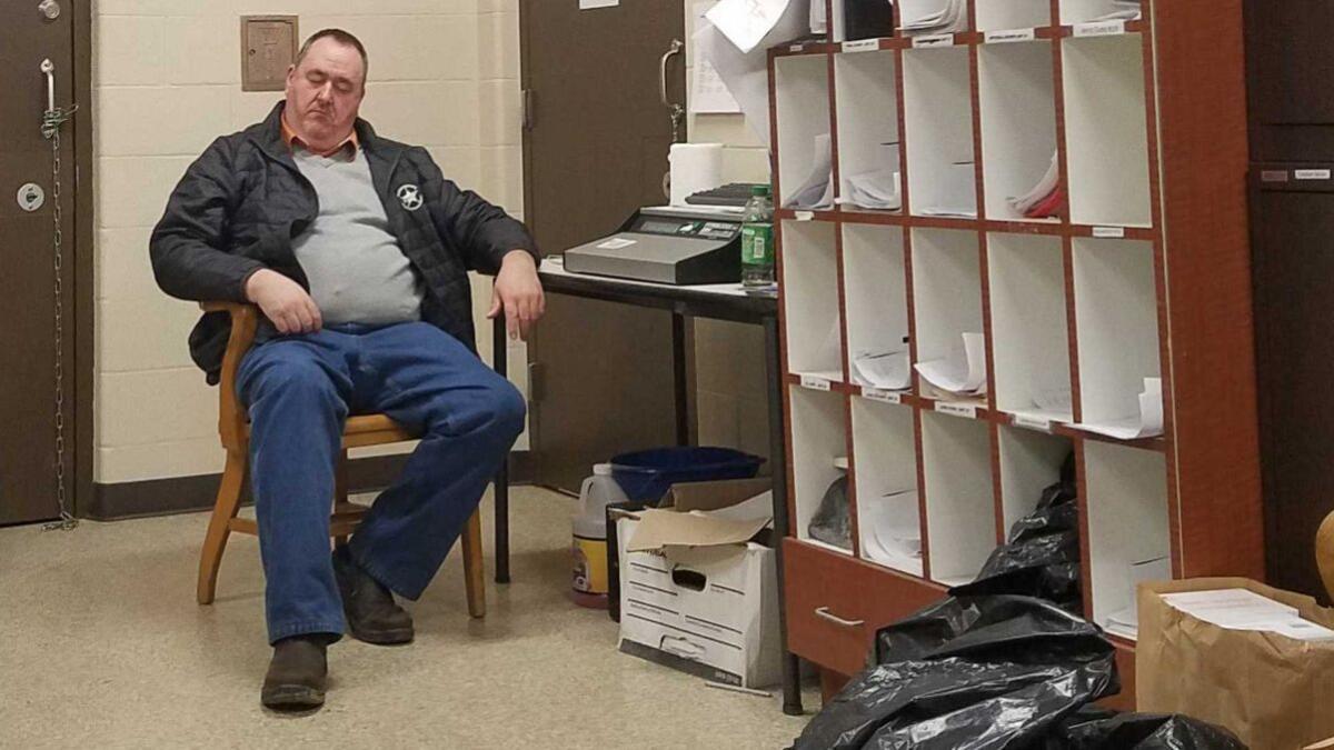 Martin County Sheriff John Kirk catches a quick nap 14 hours into his shift. Kirk often works 16-hour shifts.