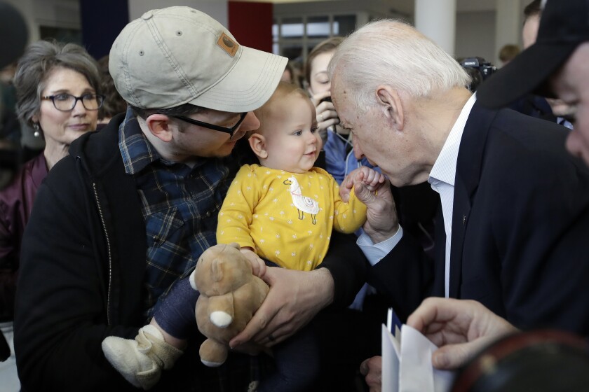 Former Vice President Joe Biden kisses a baby’s hand during a campaign event Sunday in Dubuque, Iowa.