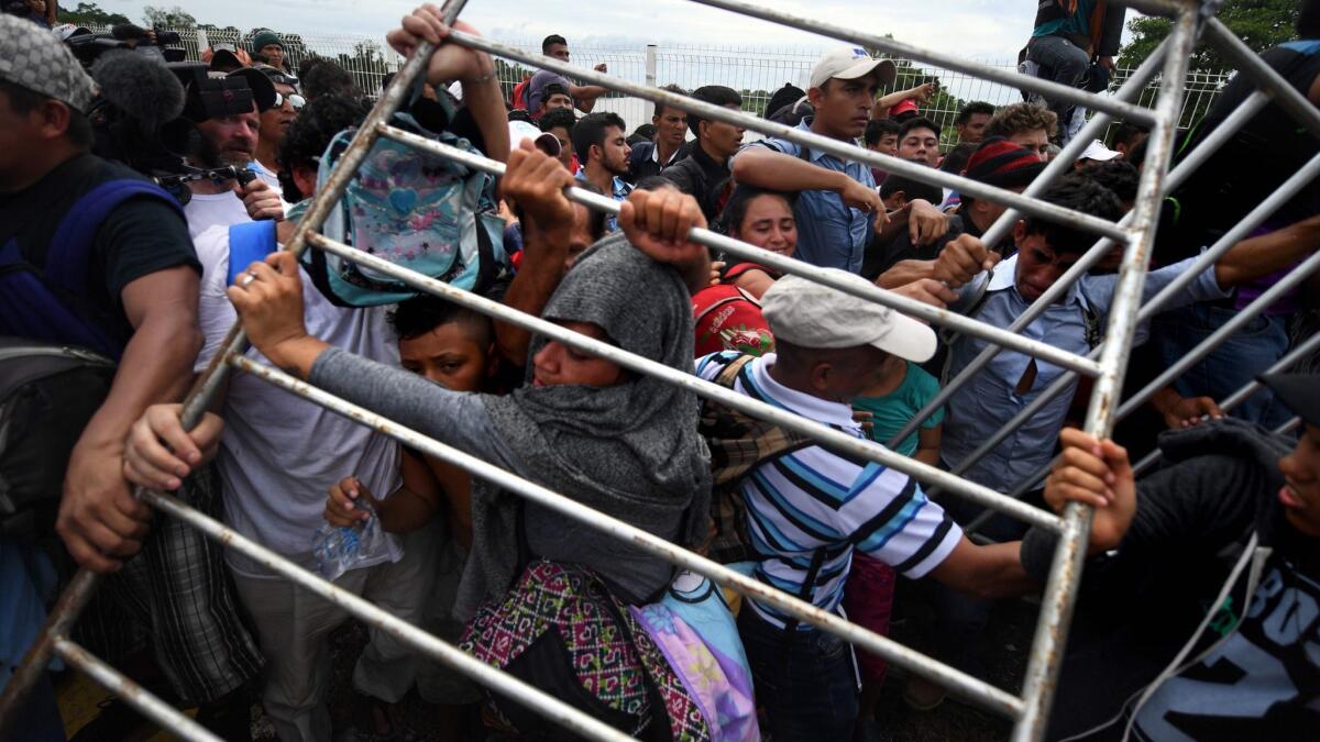 Honduran migrants remove a barrier Oct. 19 at the Guatemala-Mexico international border bridge in Ciudad Hidalgo, Chiapas state.