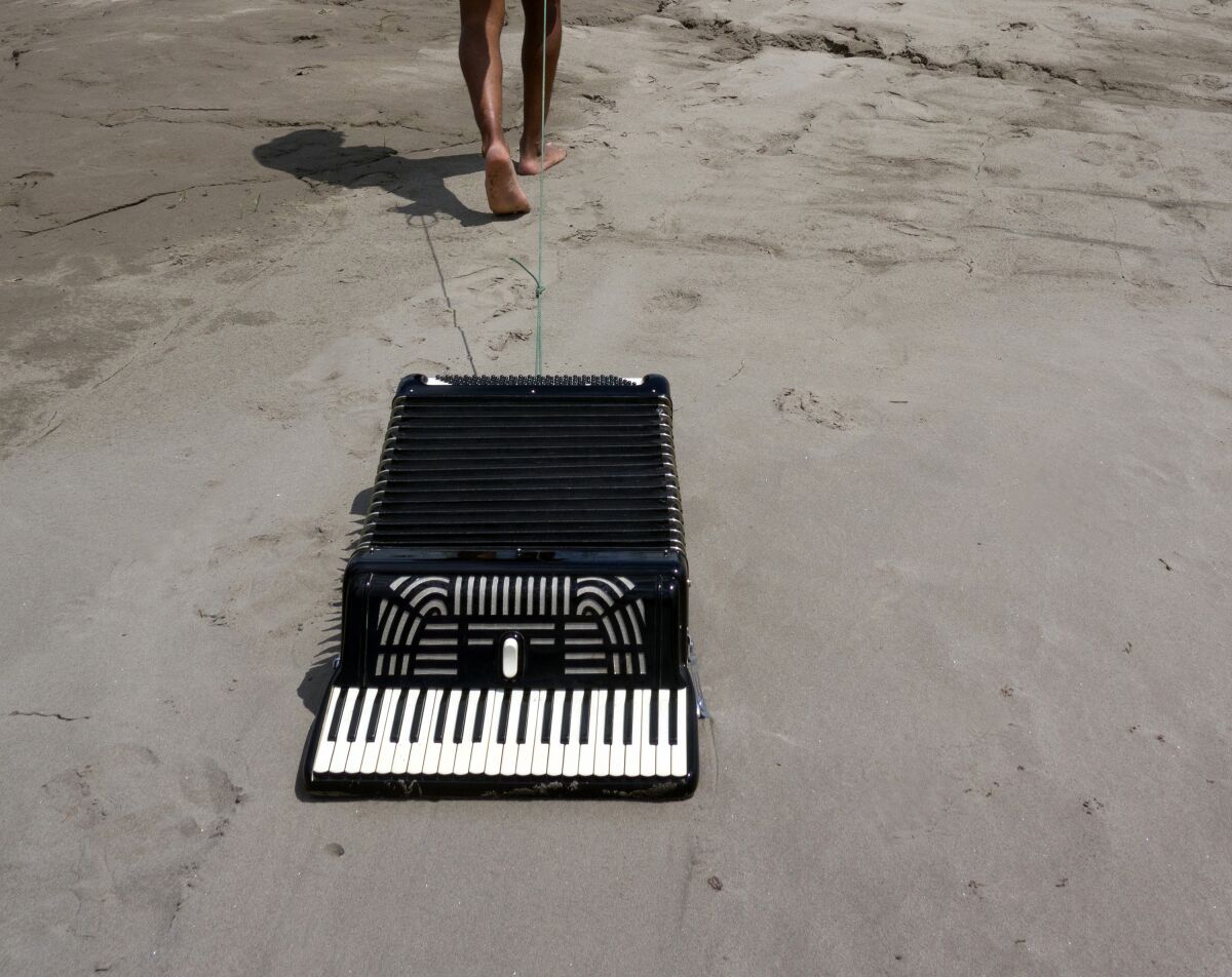 An accordion on the sand from Los Jaichackers' "Subterranean Homesick Cumbia"