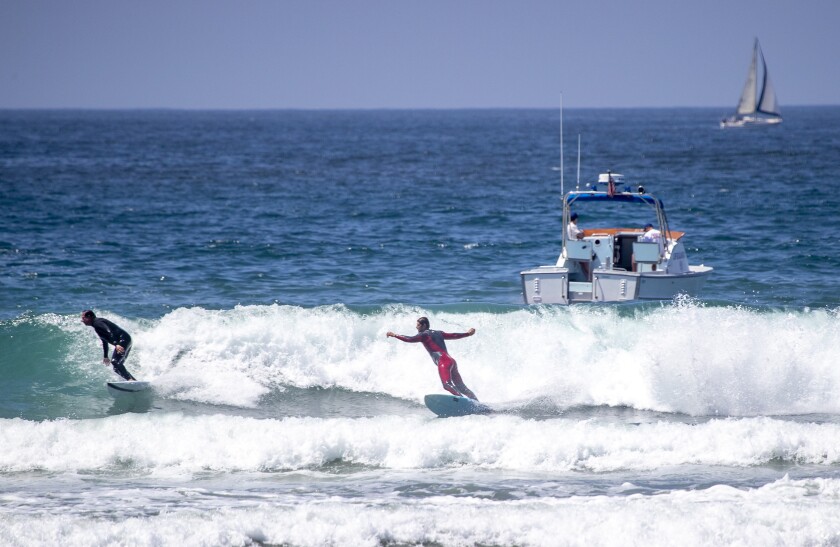 Huntington Beach lifeguards patrol trying to get surfers out of the water during a protest calling on Gov. Newsom to relax the state's stay-at-home order on Friday in Huntington Beach.
