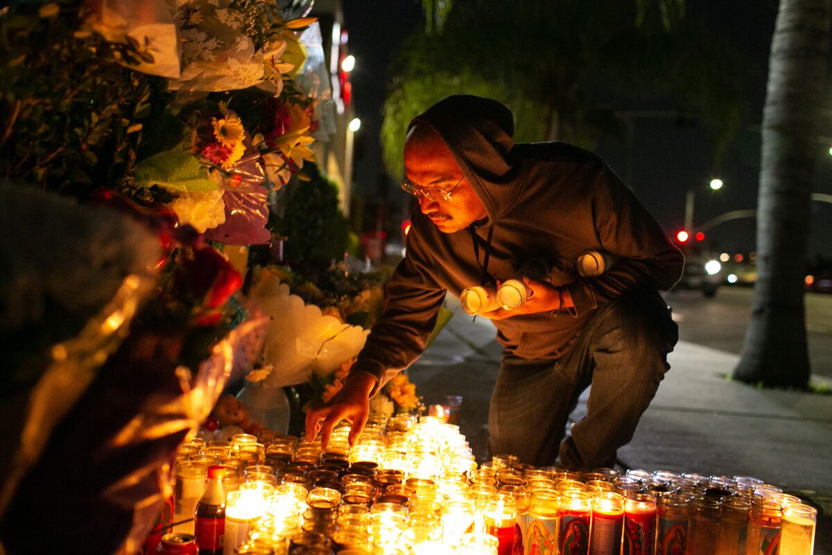 Daniel Chavarin attends to the memorial set up for his son, Xavier, who was stabbed to death last week in El Sereno.