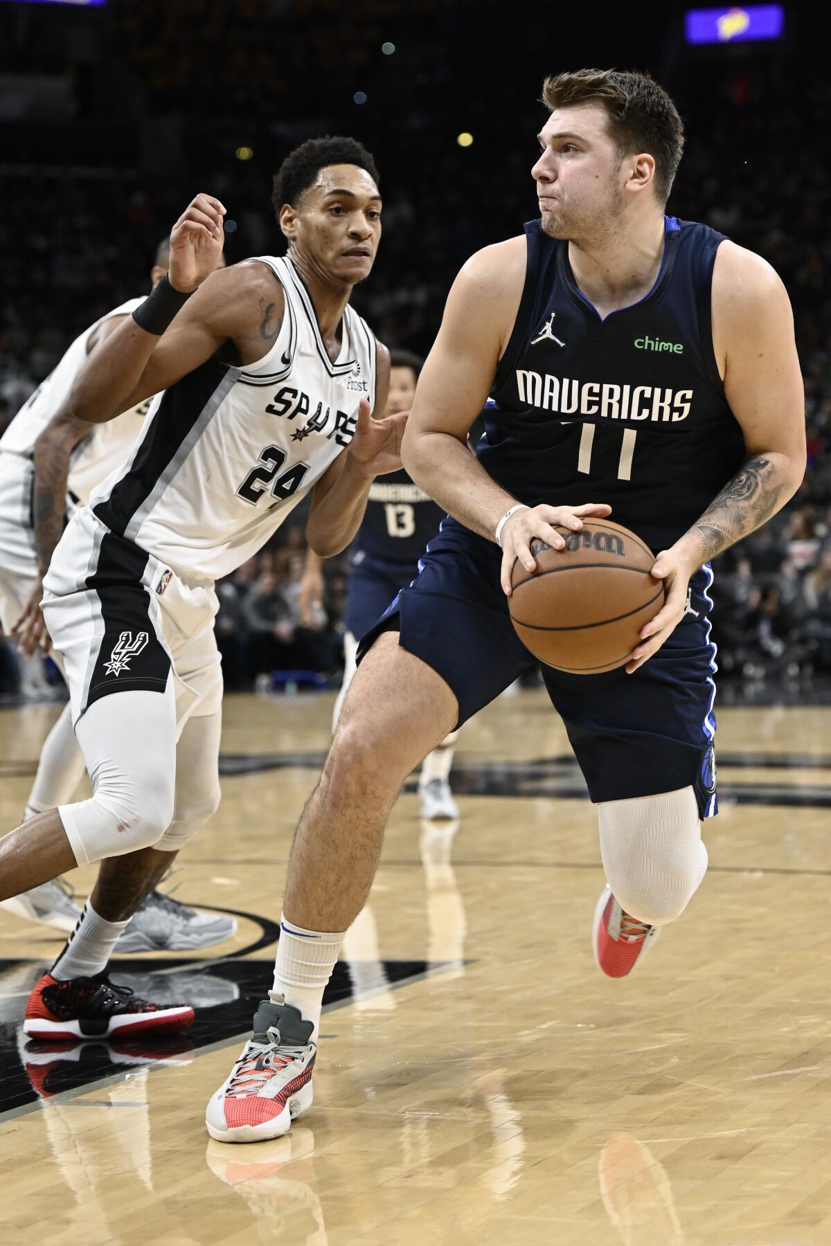 Dallas Mavericks' Luka Doncic, right, drives against San Antonio Spurs' Devin Vassell during the first half of an NBA basketball game on Wednesday, Nov. 3, 2021, in San Antonio. (AP Photo/Darren Abate)