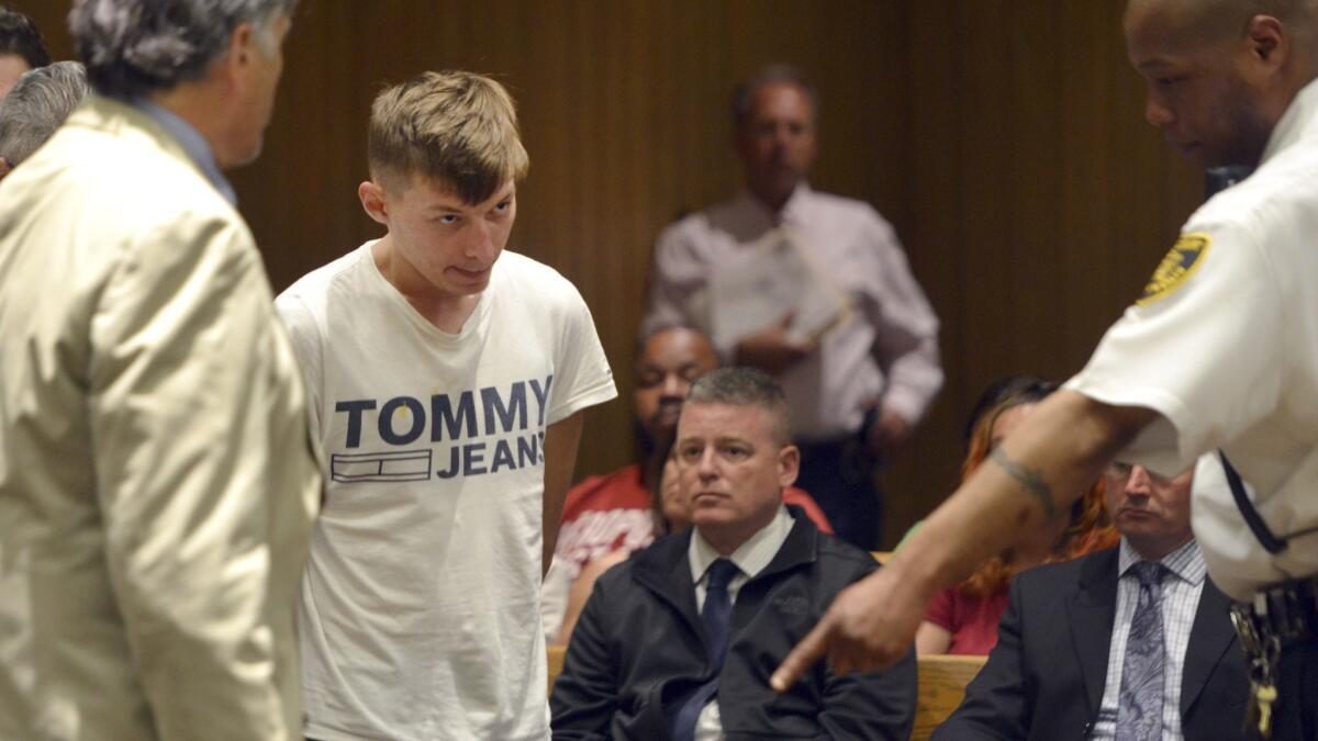 Volodymyr Zhukovskyy, 23, is escorted into the courtroom for his arraignment in Springfield, Mass.
