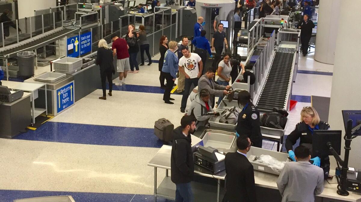 Passengers collect their belongings at United's Terminal 7 at LAX, which has automated screening lanes through security. The baggage claim area also is being renovated.