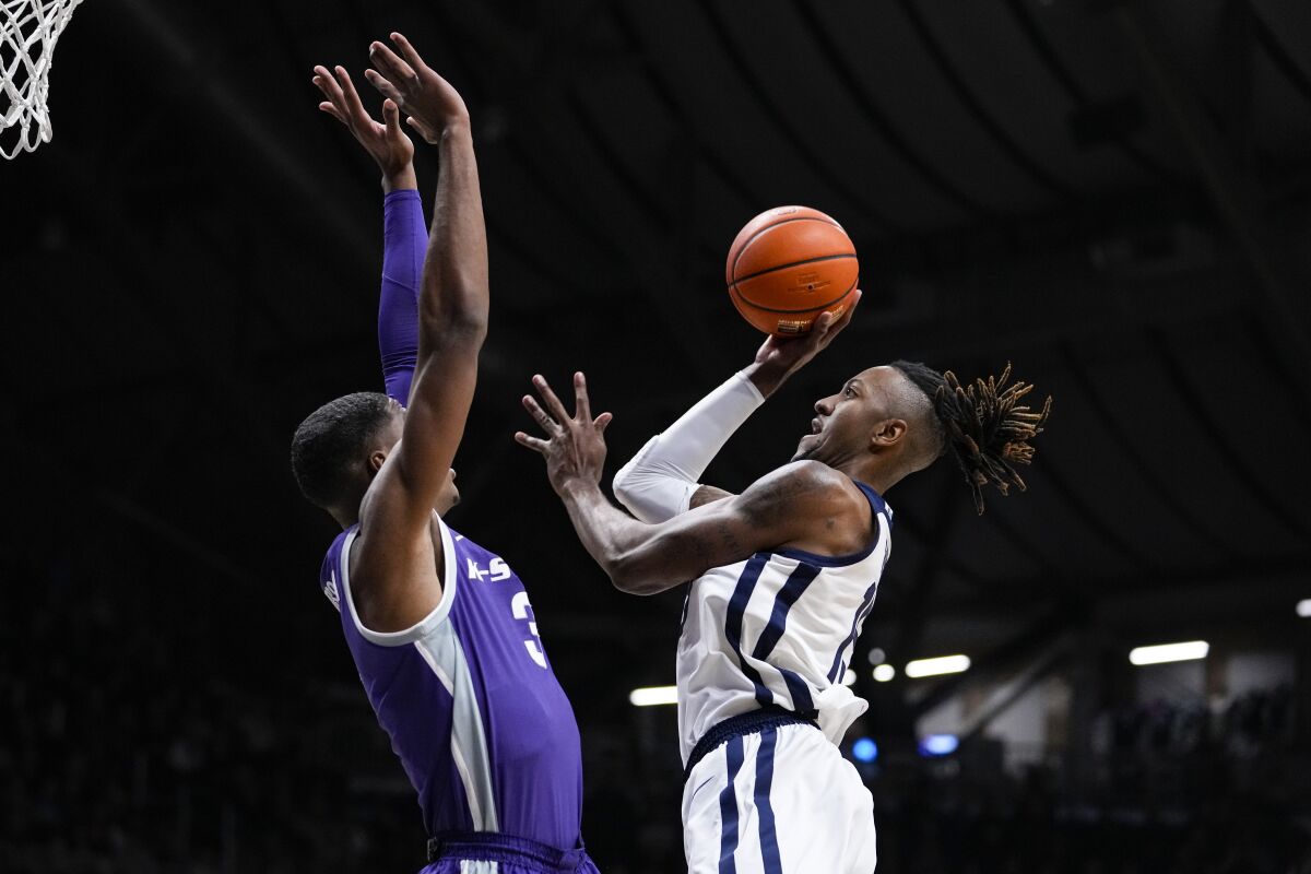 Butler center Manny Bates (15) shoots over Kansas State forward David N'Guessan (3) in the first half of an NCAA college basketball game in Indianapolis, Wednesday, Nov. 30, 2022. (AP Photo/Michael Conroy)