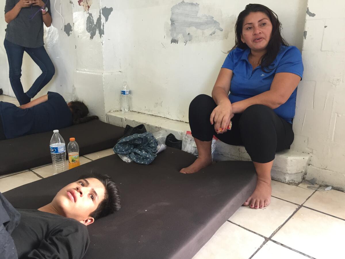 Beti Suyapa Ortega and son Robinson Javier Melara wait at a Mexican immigration agency