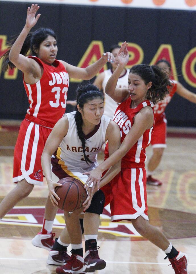 Burroughs' Abbey Ibarra (33) and Justine Barraza (21) double teams Arcadia's Kimberly Kodama on a full-court press to force a turnover in a Pacific League girls basketball game at Arcadia High School on Thursday, February 6, 2014.