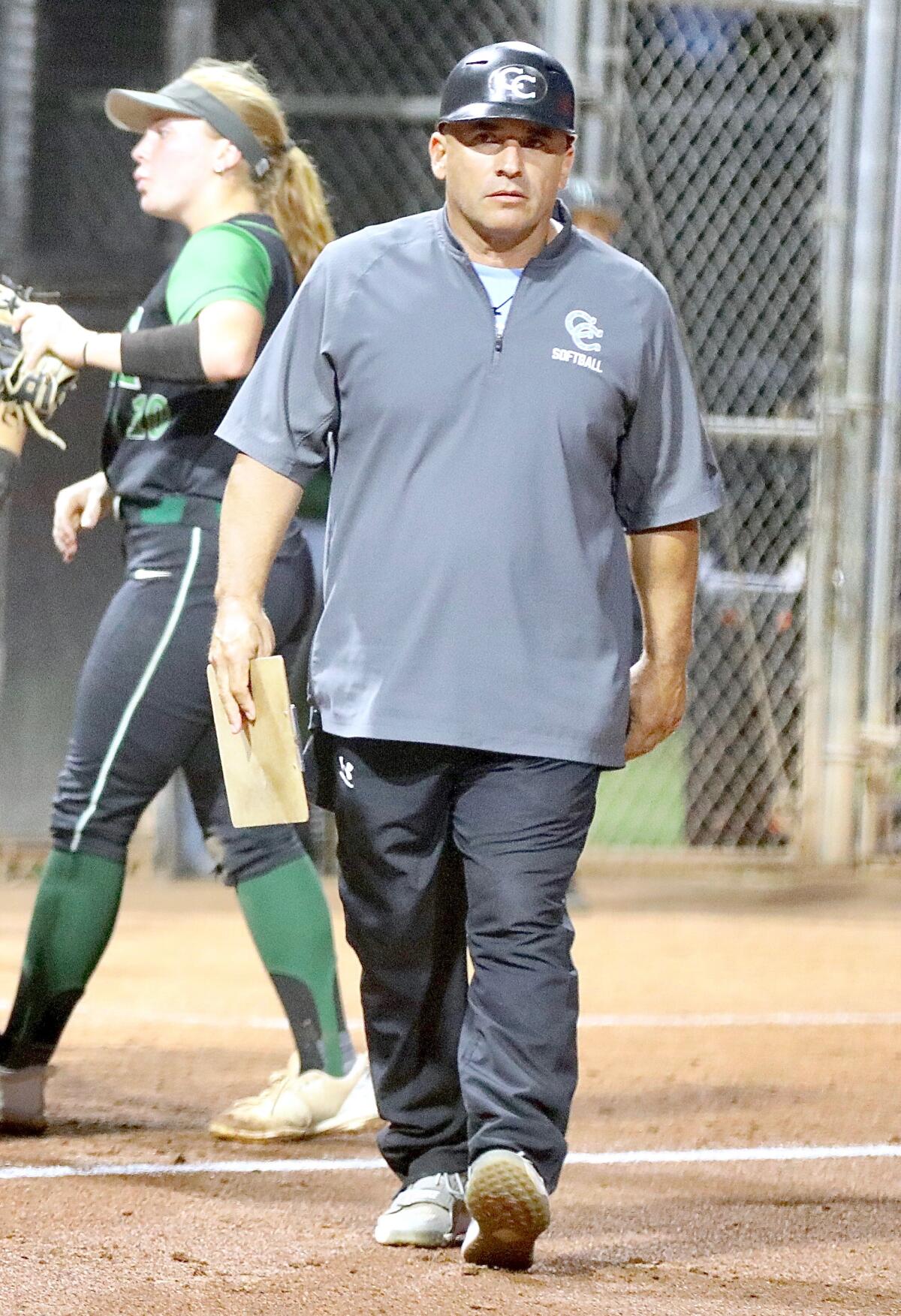 Carson softball coach Rudy Aguirre walks across the diamond.