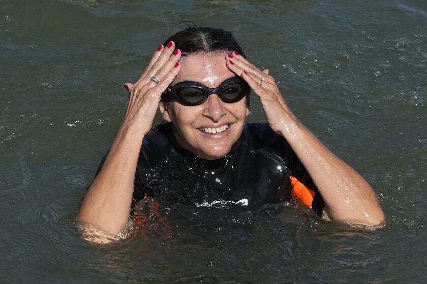 Paris Mayor Anne Hidalgo swims in the Seine river Wednesday, July 17, 2024 in Paris. After months of anticipation, Anne Hidalgo swam in the Seine Rive, fulfilling a promise she made in January nine days before the opening ceremony of the 2024 Olympics. (AP Photo/Michel Euler)