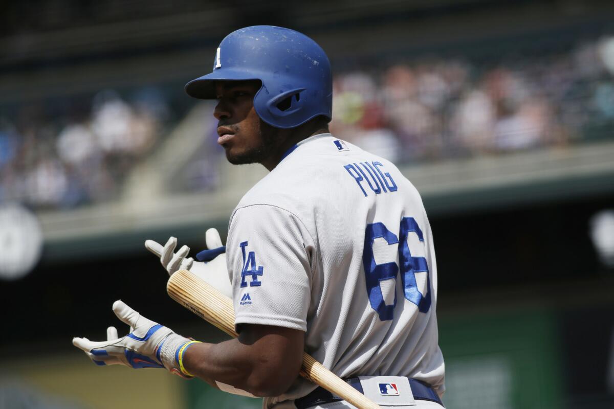 Dodgers outfielder Yasiel Puig looks to the dugout for signs as he steps out of the batter's box while facing the Rockies on Apr. 24.