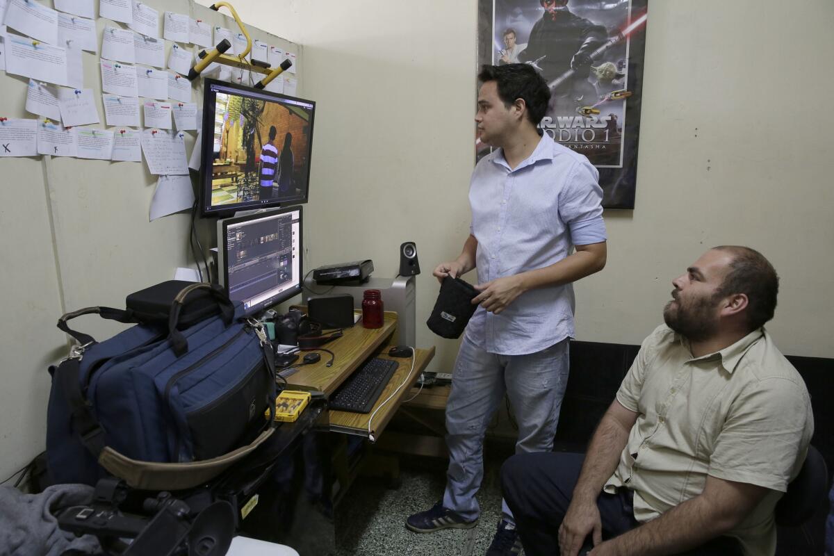 Fotografía fechada el 10 de julio de 2017 que muestra a los jóvenes cineastas salvadoreños Fabricio Sibrian (i) y Jaime Perla (d) mientras observan un monitor en San Salvador (El Salvador).