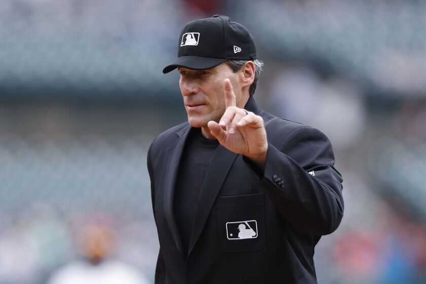 FILE - Home plate umpire Ángel Hernández signals during a baseball game between the Detroit Tigers and the Minnesota Twins, Sept. 1, 2019, in Detroit. A federal appellate court panel appeared to be skeptical Thursday, June 8, 2023, of an attempt by umpire Ángel Hernández to reinstate his race discrimination lawsuit against Major League Baseball. (AP Photo/Carlos Osorio, File)