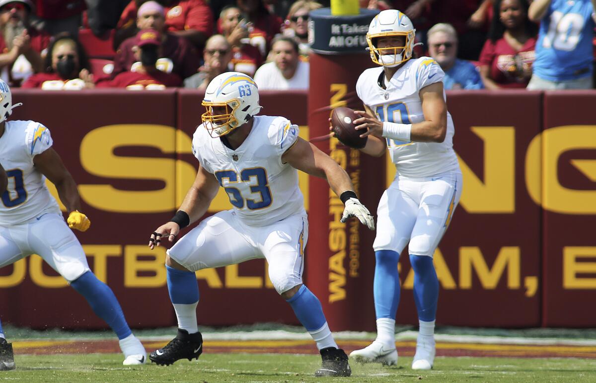 Chargers center Corey Linsley (63) checks for opposing pass rushers after snapping the ball.