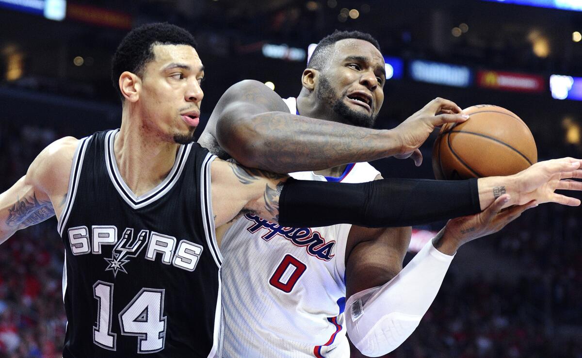 Clippers forward Glen Davis grabs a rebound before Spurs guard Danny Green can get to it in the first half of Game 1.