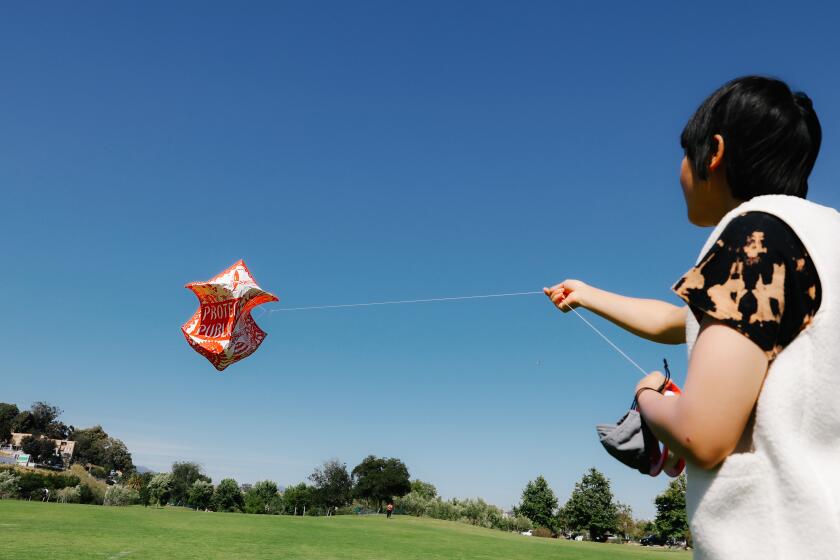 LOS ANGELES-CA-MAY 11, 2022: Master kite maker Stevie Choi tests out a kite at LA State Historic Park on Thursday, May 12, 2022. (Christina House / Los Angeles Times)