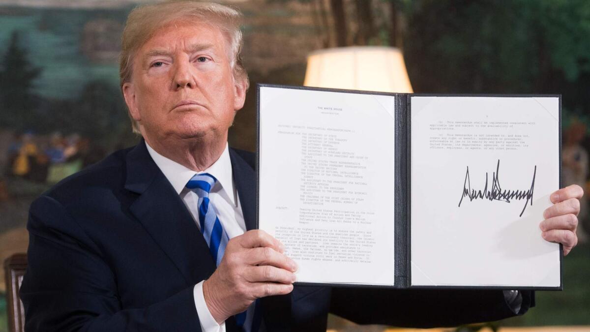 President Trump holds document reinstating sanctions against Iran after announcing U.S. withdrawal from the Iran nuclear deal on Tuesday.