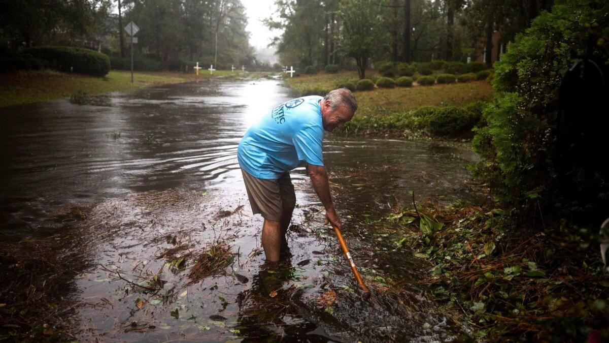 Mandatory Credit: Photo by JIM LO SCALZO/EPA-EFE/REX/Shutterstock (9882790v) Barry Shape attempts to clear debris from a storm drain as Hurricane Florence comes ashore in Wilmington, North Carolina USA, 14 September 2018. Hurricane Florence has been downgraded to a category 1 storm on the Saffir-Simpson Hurricane Wind Scale, though is still expected to bring a storm surge with heavy flooding to the Carolinas. Hurricane Florence Strikes East Coast of United States, Wilmington, USA - 14 Sep 2018 ** Usable by LA, CT and MoD ONLY **