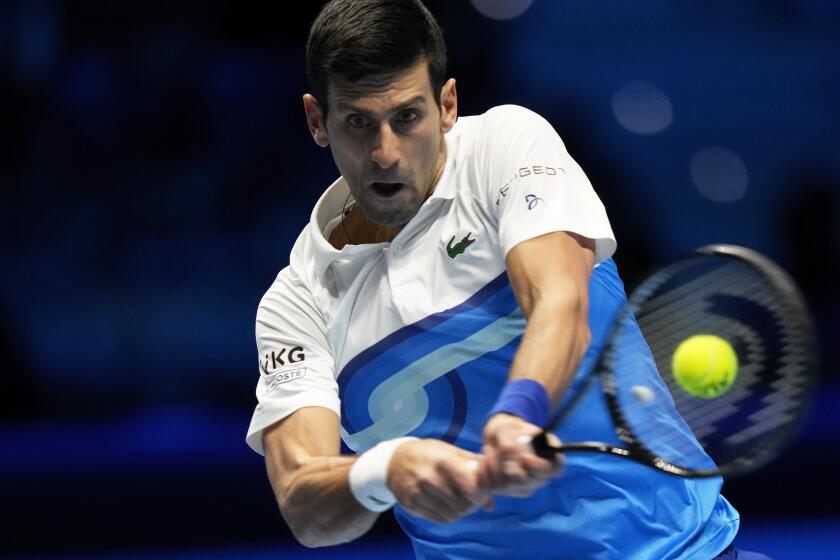 Novak Djokovic of Serbia returns with a backhand to Alexander Zverev of Germany during their ATP World Tour Finals.