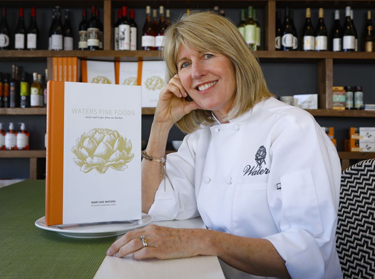 Mary Kay Waters, owner of Waters Fine Foods and Catering, photographed in 2019 with her cookbook 