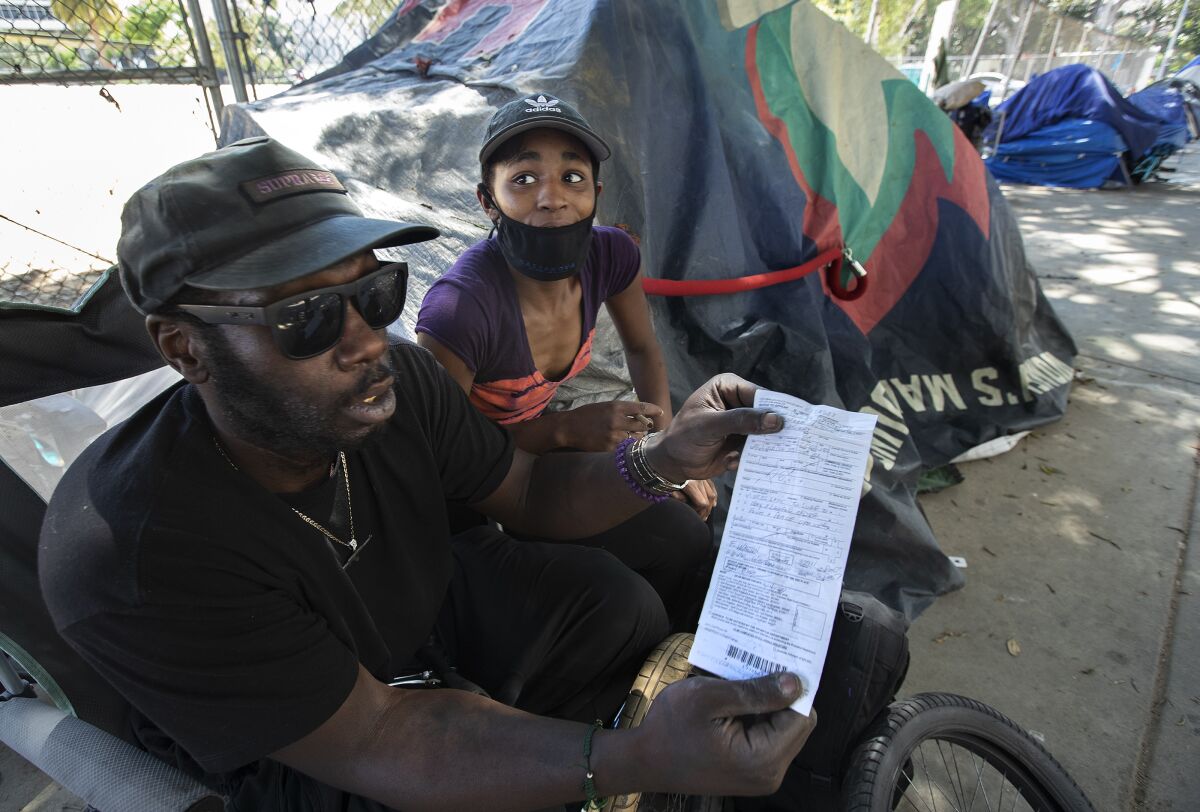 Alex Jones and his girlfriend, Maya Johnson, are shown at a homeless encampment near 1st and Spring streets in downtown L.A.
