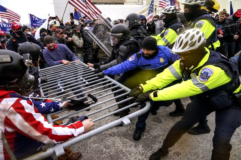 A mob at the Capitol pulls down barricades Jan. 6.