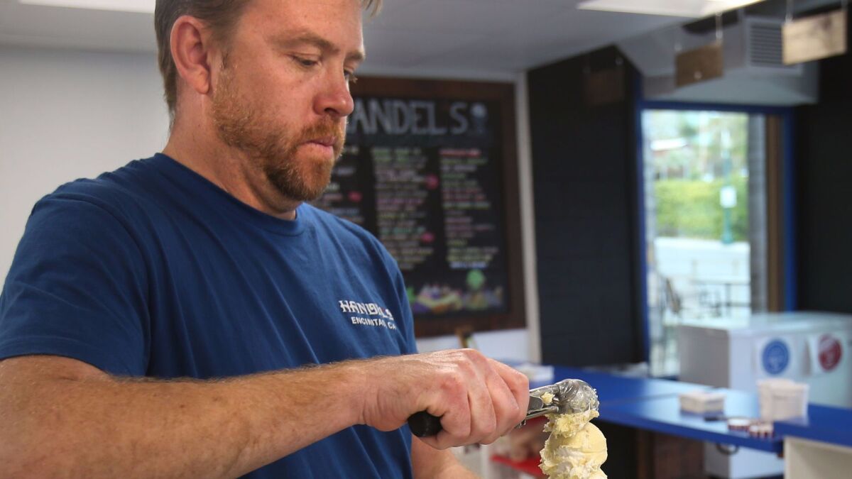 Ken Schulenburg packs a cone with ice cream Tuesday at his shop Handel's Homemade Ice Cream in Encinitas.