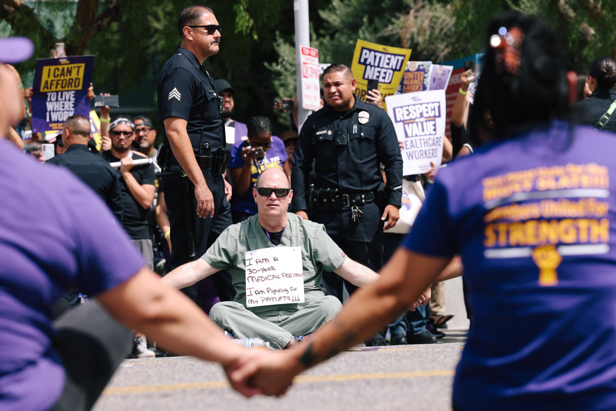 People form a human circle on West Sunset Boulevard during a demonstration with thousands of healthcare workers.