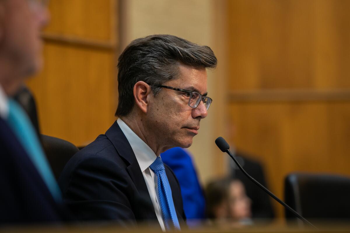 Councilmember Stephen Whitburn looks out to towards attendees at a public meeting.