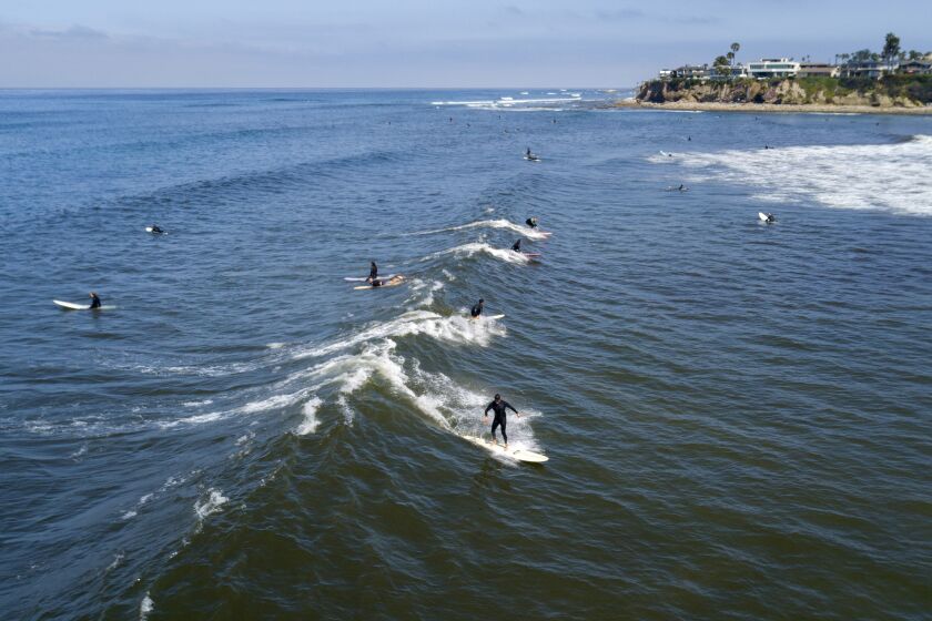 A surfer rides a wave in Tourmaline Surf Park in Pacific Beach after local beaches reopened to activities such as walking, running, and surfing on April 27, 2020. Beaches have been closed for several weeks due to the coronavirus. The boardwalks are still off limits and gathering on the sand is not allowed.