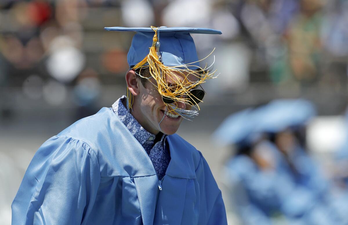 A Corona del Mar graduate has his tassel tangled in the wind.